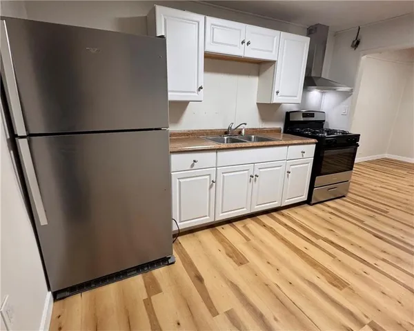 a kitchen with granite countertop white cabinets and black appliances
