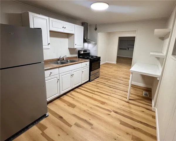 a kitchen with a refrigerator and a stove