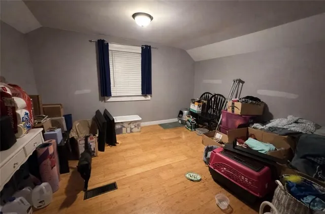 a room with gym equipment and wooden floor