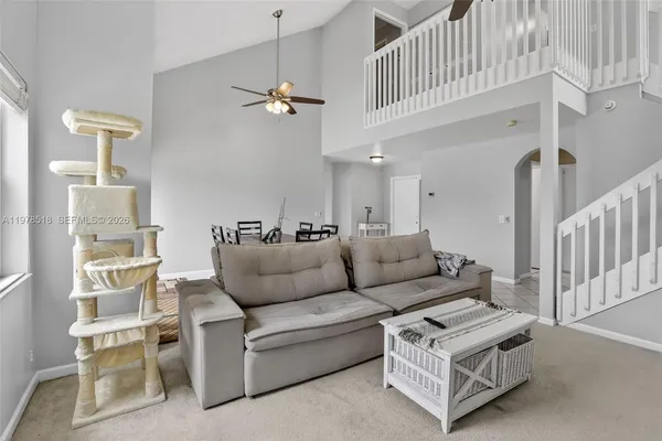 a living room with furniture a ceiling fan and a rug