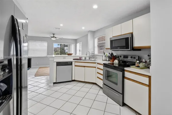 a kitchen with stainless steel appliances granite countertop a refrigerator sink and microwave