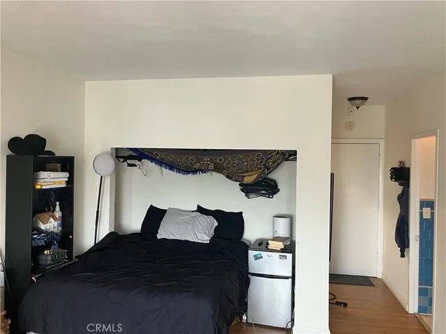 a bedroom with a bed and wooden floor
