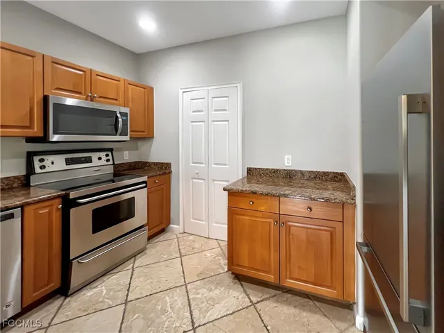 a kitchen with stainless steel appliances granite countertop a stove microwave and refrigerator