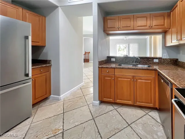 a kitchen with stainless steel appliances granite countertop a stove a refrigerator and a sink