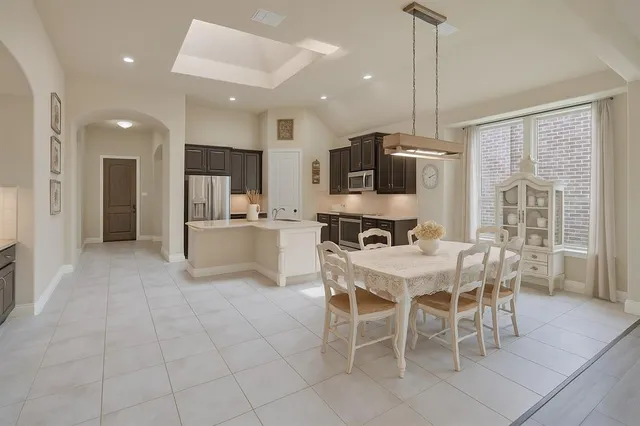 a kitchen with stainless steel appliances kitchen island granite countertop a refrigerator and a stove top oven