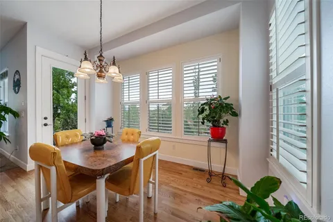 a dining room with furniture window and wooden floor