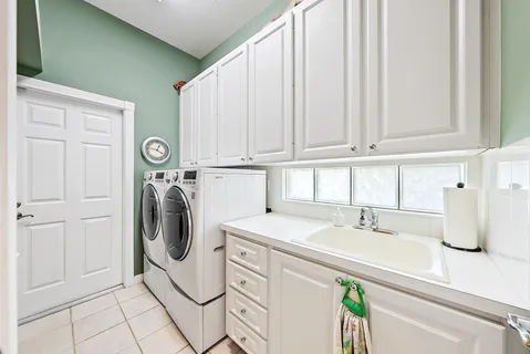 a utility room with sink dryer and washer