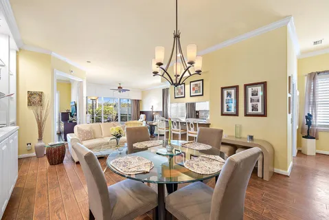 a dining room with furniture a chandelier and wooden floor