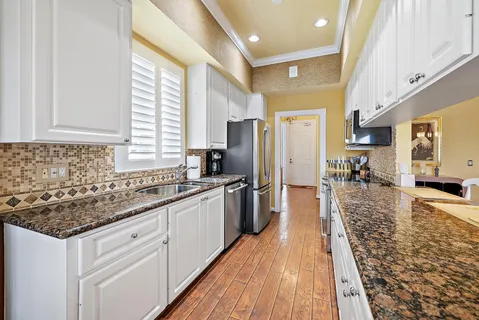 a kitchen with stainless steel appliances granite countertop a sink stove and refrigerator