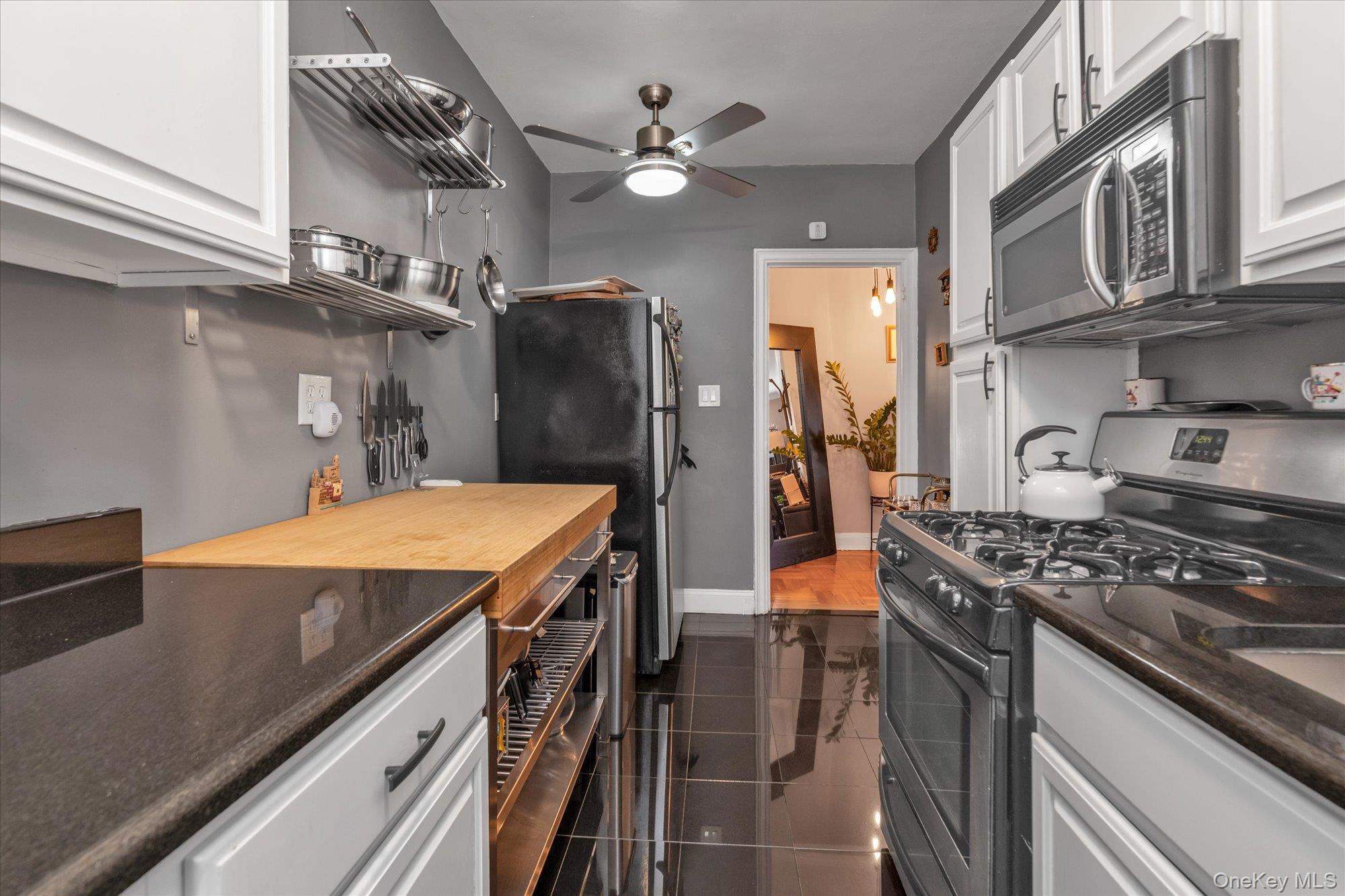 48-55 43rd Street, Unit 3F Queens, NY 11377 - Photo 7 of 12 a kitchen with stainless steel appliances a stove a sink dishwasher and cabinets with wooden floor
