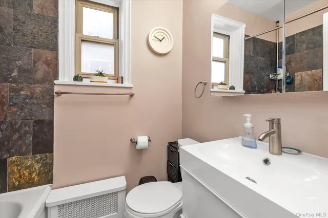 a bathroom with a sink a toilet and a mirror