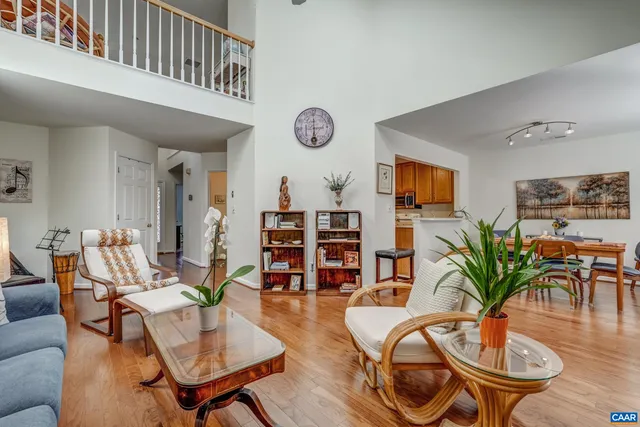 a living room with furniture a bookshelf and wooden floor