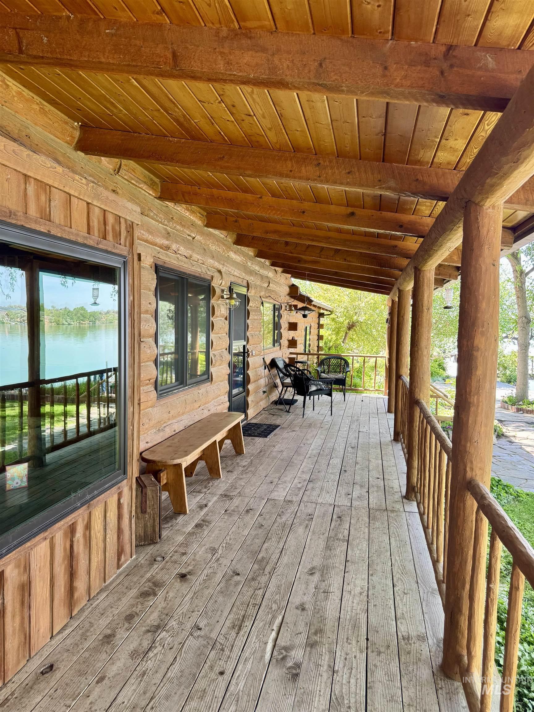 62 Bell Rapids Road Hagerman, ID 83332 - Photo 7 of 34 Expansive log cabin porch featuring a wood-finish floor and ceiling, log pillars, and a natural wood railing