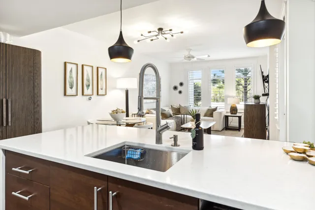a kitchen with a sink a counter and chairs