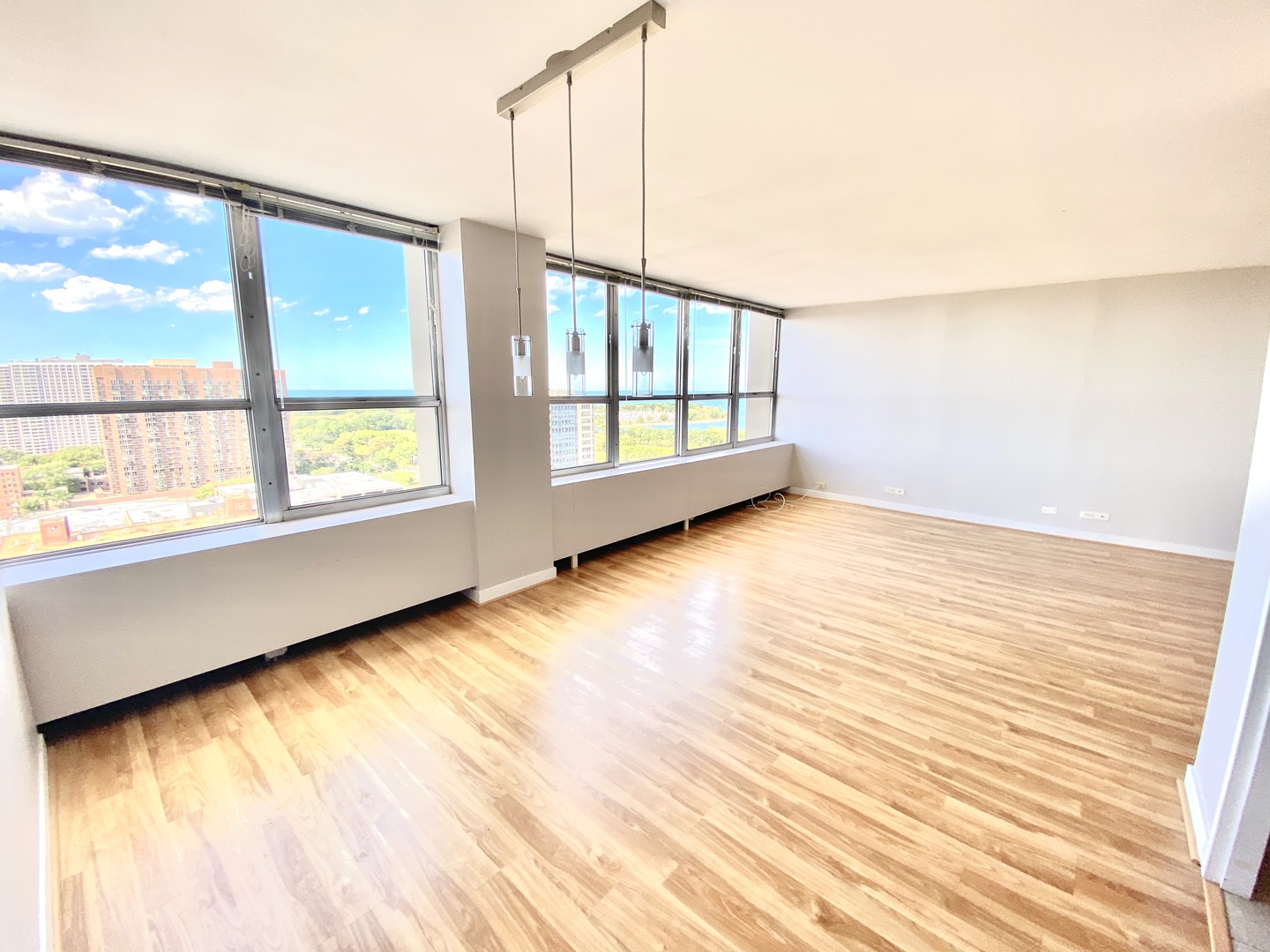655 West Irving Park Road, Unit 2112 Chicago, IL 60613 - Photo 5 of 49 a view of an empty room with wooden floor and a window
