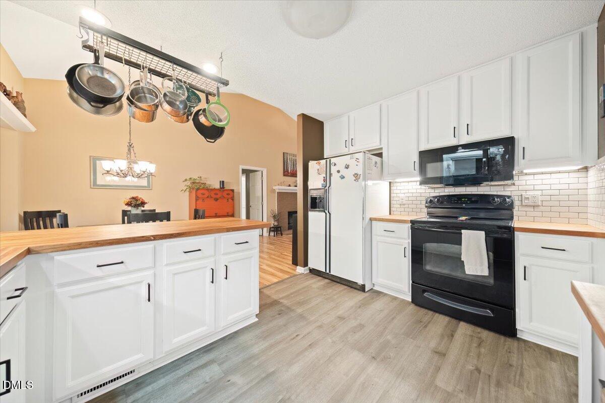 5216 Relay Way Raleigh, NC 27603 - Photo 11 of 27 a kitchen with white cabinets and stainless steel appliances