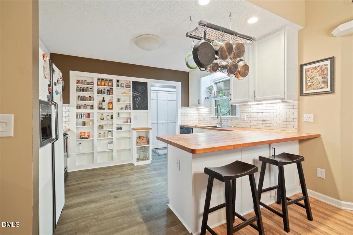 5216 Relay Way Raleigh, NC 27603 - Photo 7 of 27 a kitchen with stainless steel appliances kitchen island granite countertop a table and chairs in it