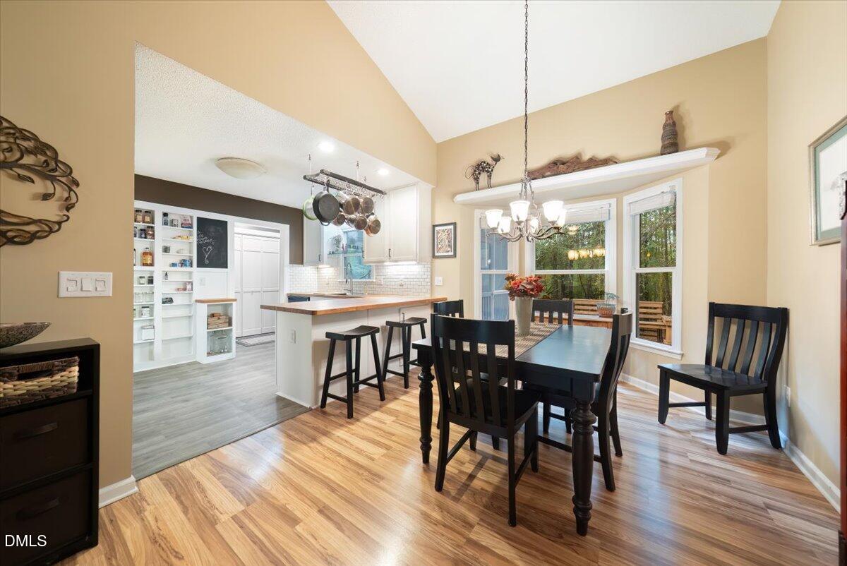 5216 Relay Way Raleigh, NC 27603 - Photo 8 of 27 a dining room with furniture a floor to ceiling window and wooden floor
