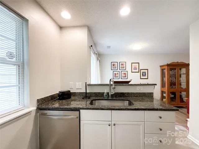 a kitchen with granite countertop a sink and a window