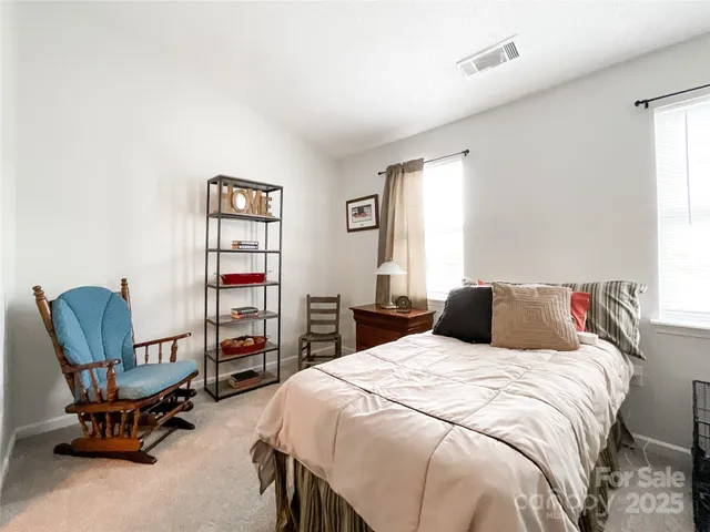 a bedroom with a bed a chair and dresser