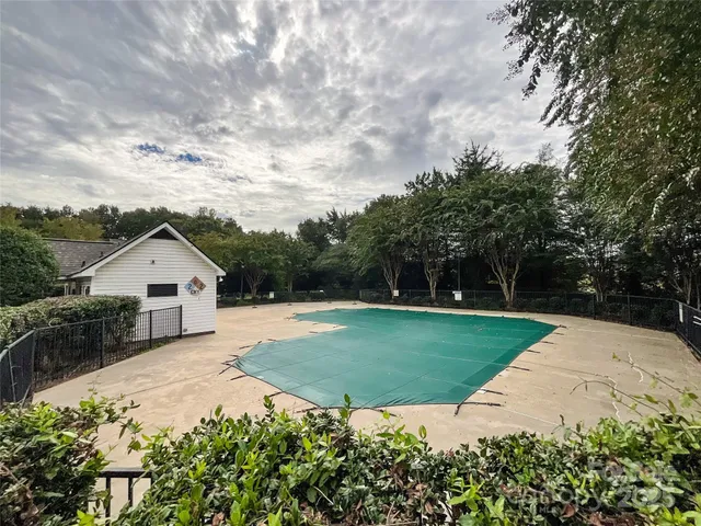 a view of a house with a big yard potted plants and large tree