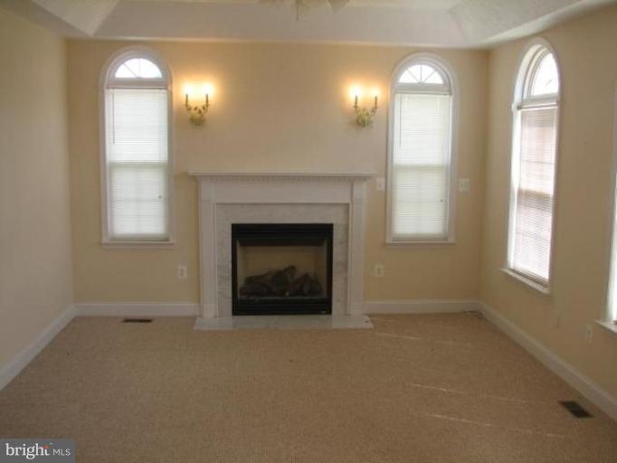 6320 Scaggs Road Owings, MD 20736 - Photo 3 of 4 an empty room with windows and fireplace