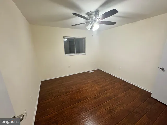 a view of a big room with wooden floor and a chandelier fan