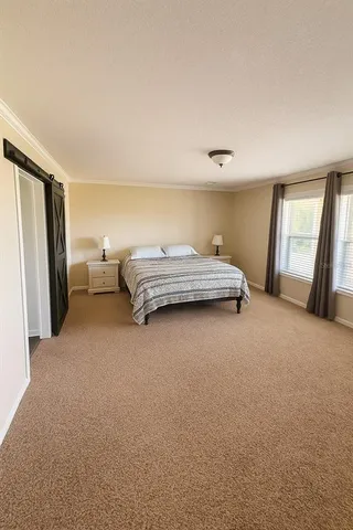 a bedroom with a bed and a large mirror
