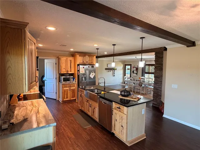 a kitchen with stainless steel appliances kitchen island granite countertop a stove and a refrigerator