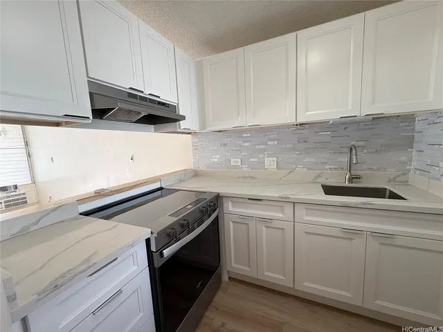 a kitchen with white cabinets and white appliances
