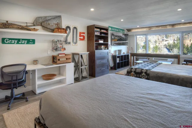 a bedroom with furniture and a large window