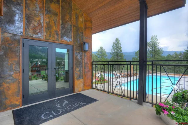 a view of a swimming pool with a patio and a yard