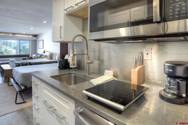a kitchen with a stove and a wooden floor