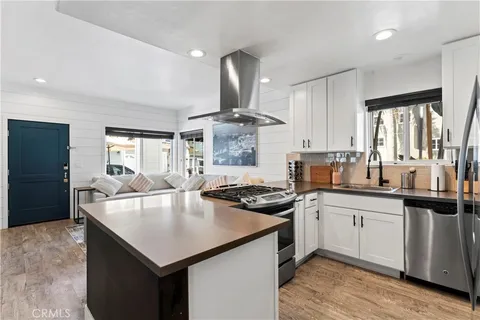 a kitchen with stainless steel appliances granite countertop a sink a stove and refrigerator