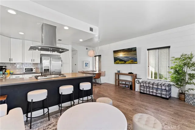 a kitchen with stainless steel appliances granite countertop a stove a sink a dining table and chairs