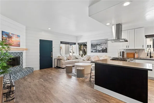 a open kitchen with stainless steel appliances granite countertop a sink dishwasher stove and refrigerator with wooden floor