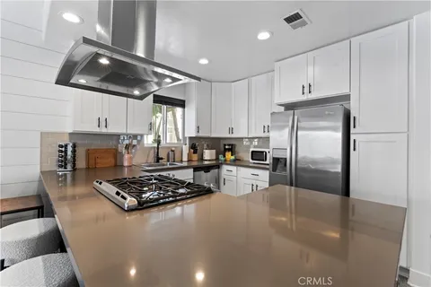 a kitchen with stainless steel appliances granite countertop a sink stove and refrigerator