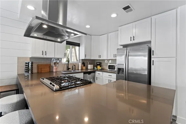 a kitchen with stainless steel appliances granite countertop a sink stove and refrigerator