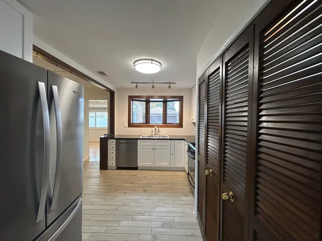 a kitchen with stainless steel appliances granite countertop a refrigerator and a sink