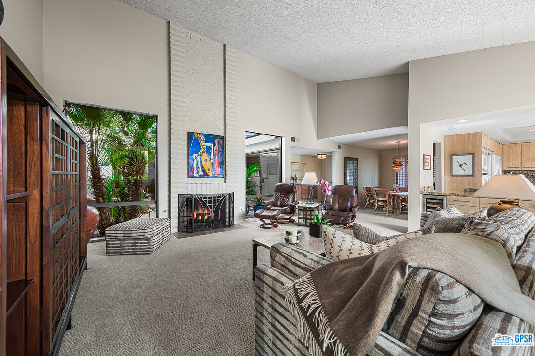 75 Durango Circle Rancho Mirage, CA 92270 - Photo 5 of 37 a living room with furniture a fireplace and a large window