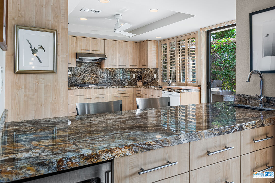75 Durango Circle Rancho Mirage, CA 92270 - Photo 8 of 37 a kitchen with kitchen island granite countertop a large window and cabinets