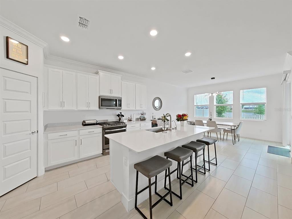 8312 Rolling Tides Drive New Port Richey, FL 34655 - Photo 25 of 49 a view of kitchen with cabinets table and chairs