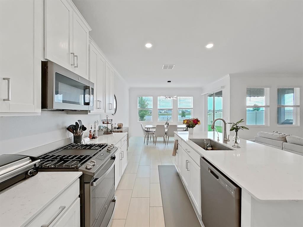 8312 Rolling Tides Drive New Port Richey, FL 34655 - Photo 27 of 49 a kitchen with sink stove and cabinets