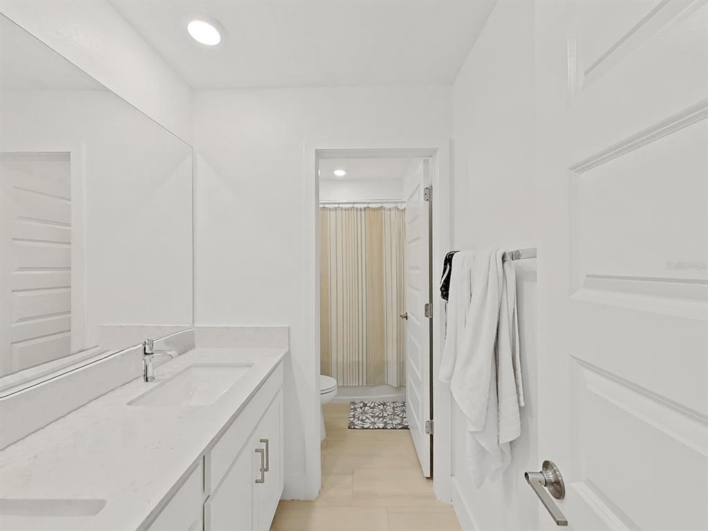 8312 Rolling Tides Drive New Port Richey, FL 34655 - Photo 38 of 49 a bathroom with a double vanity sink a toilet and a tub