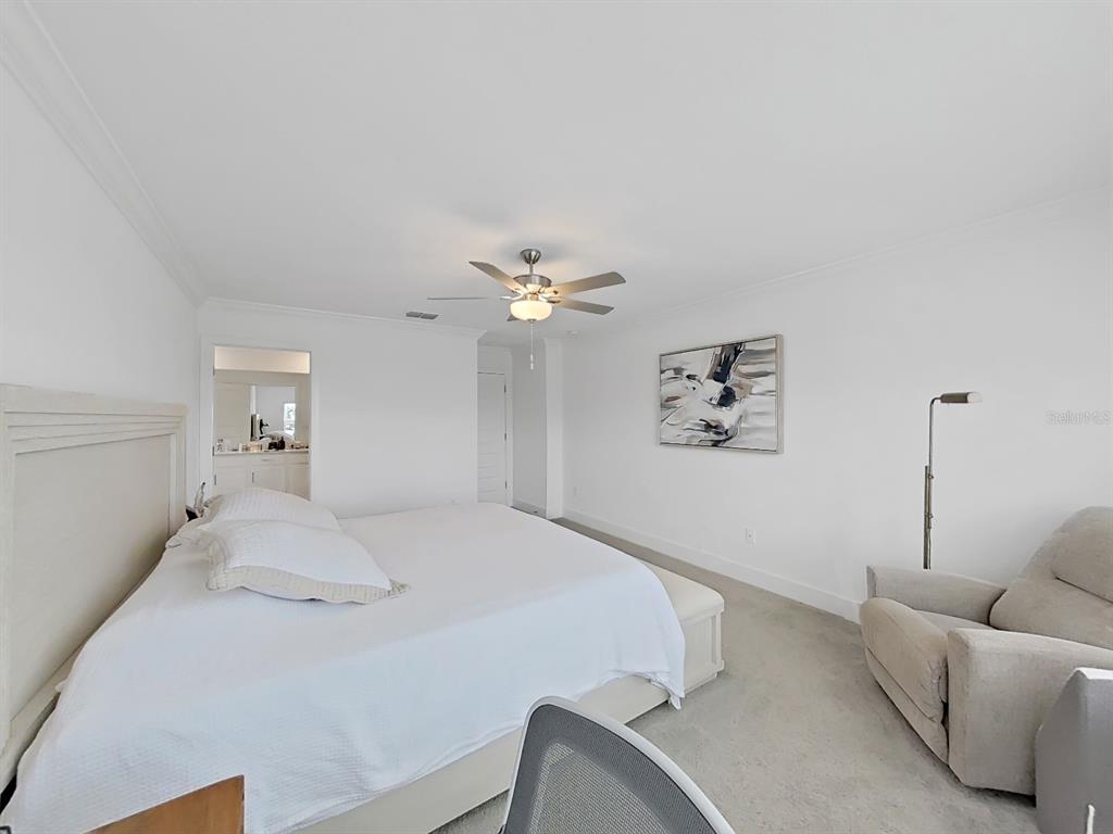 8312 Rolling Tides Drive New Port Richey, FL 34655 - Photo 43 of 49 a bedroom with a bed and a chandelier