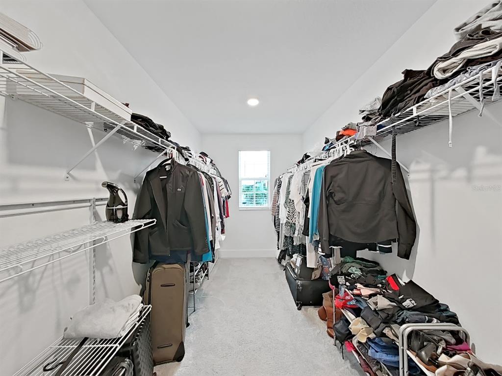 8312 Rolling Tides Drive New Port Richey, FL 34655 - Photo 45 of 49 a view of walk in closet with clothes and shoes