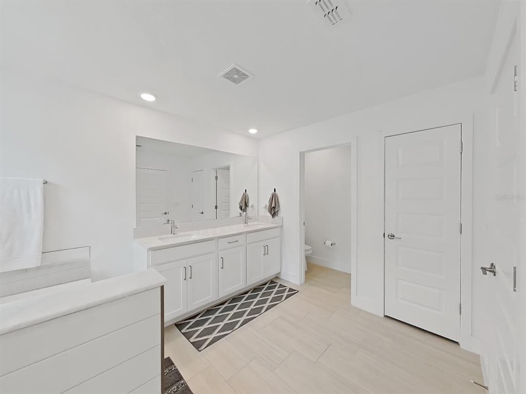 8312 Rolling Tides Drive New Port Richey, FL 34655 - Photo 46 of 49 a spacious bathroom with a double vanity sink a mirror and a bathtub