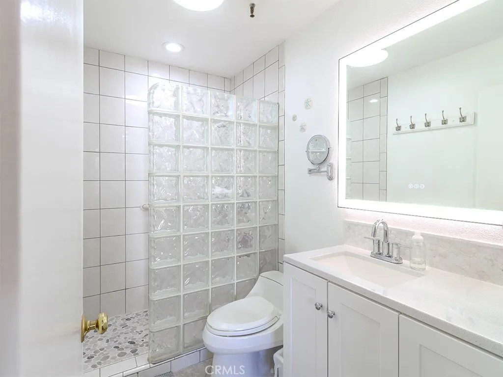 18900 Delaware Street Huntington Beach, CA 92648 - Photo 11 of 21 a bathroom with a sink toilet and shower