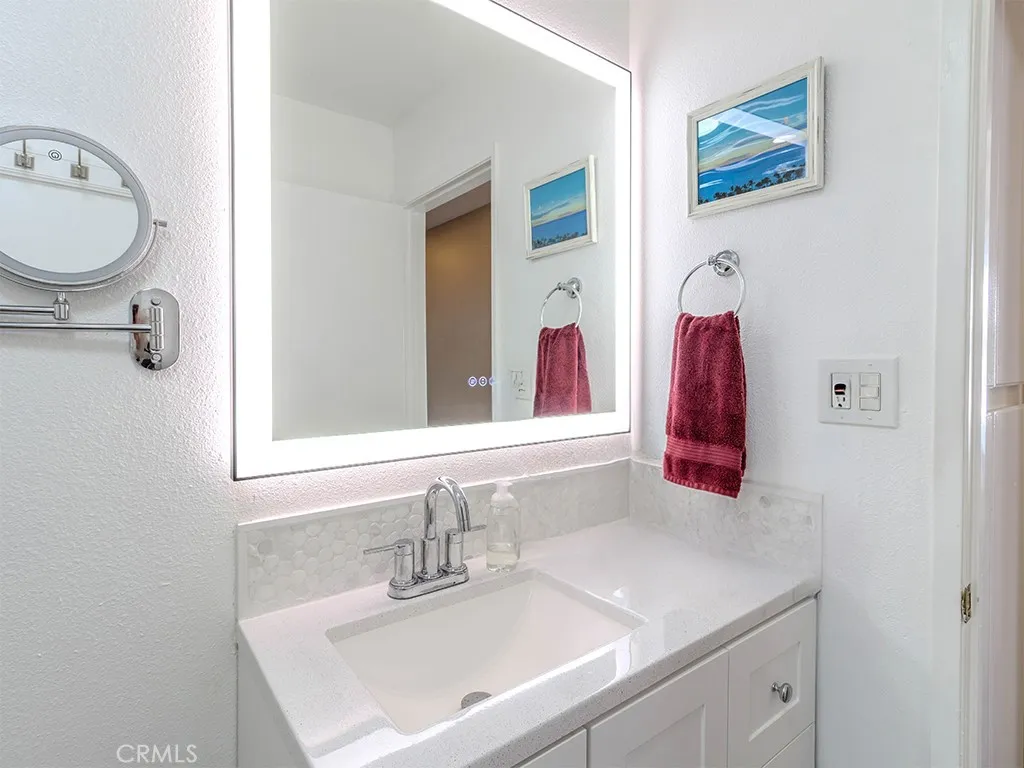 18900 Delaware Street Huntington Beach, CA 92648 - Photo 12 of 21 a bathroom with a sink vanity and a mirror