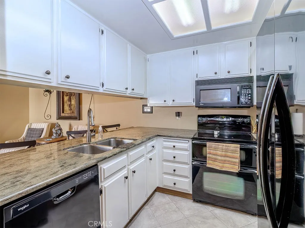 18900 Delaware Street Huntington Beach, CA 92648 - Photo 8 of 21 a kitchen with granite countertop a sink stove and cabinets